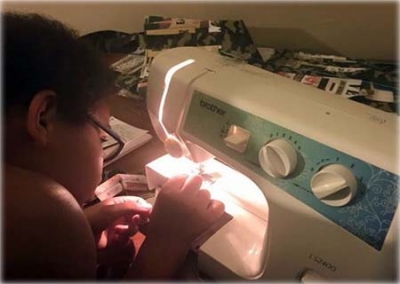 Menino de 10 anos faz roupas para moradores de rua