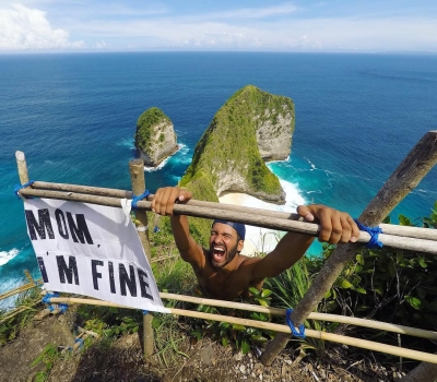 Conheça o jovem que está viajando o mundo com um cartaz escrito “Mãe, estou bem”