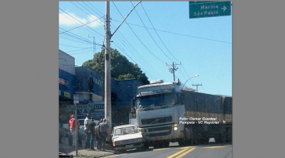Carreta prensa carro em poste e fere motorista
