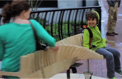 Banco giratório faz as pessoas rirem em praça pública