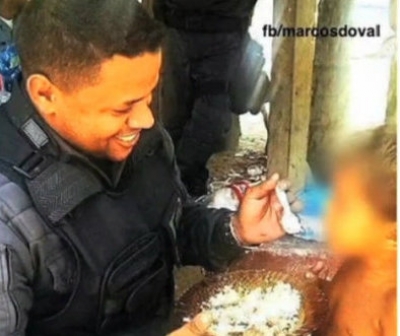 Policial divide comida com criança em favela
