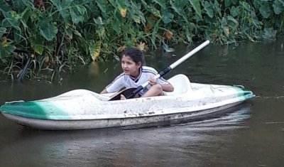 Menina de 7 anos usa caiaque para poder estudar após temporal