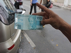 Homem joga dinheiro na rua                      e gera tumulto