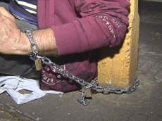 Homem se acorrenta a poste         por cirurgia da filha